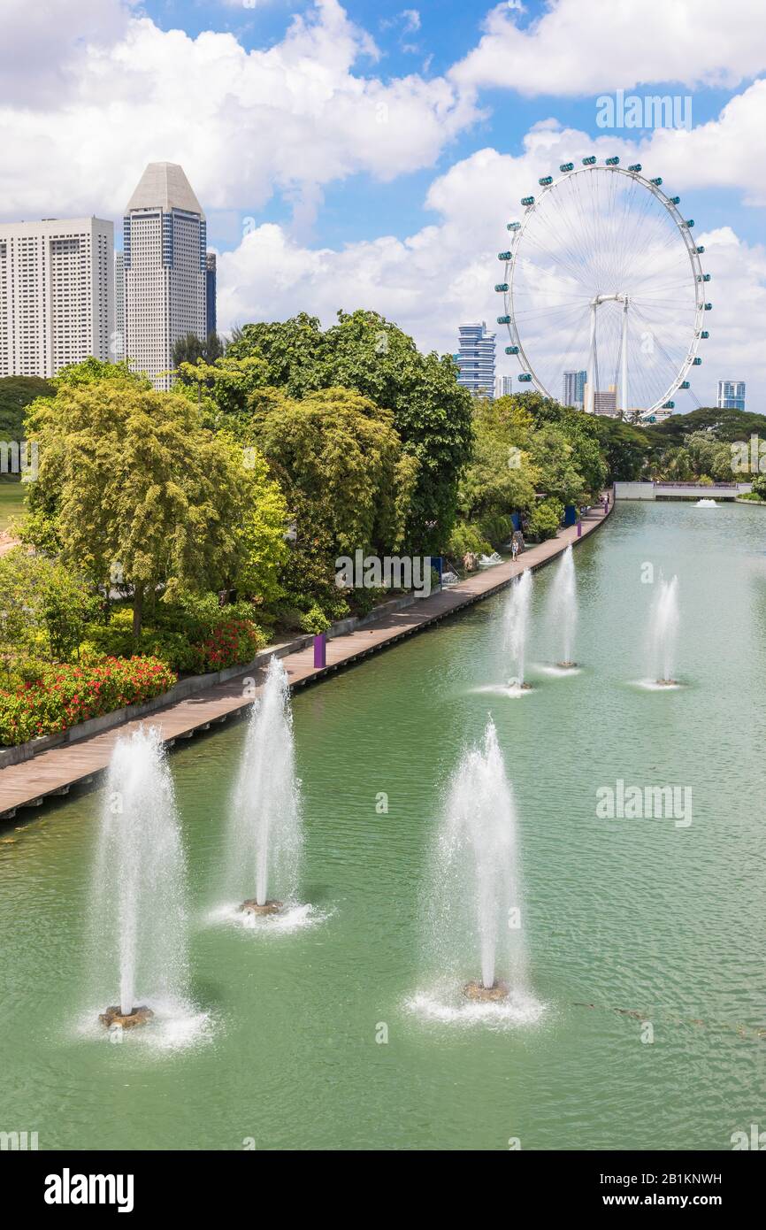 Fuentes de agua en el parque público, Jardines en la Bahía con el Singapore Flyer y rascacielos en el horizonte, Singapur, Asia Foto de stock