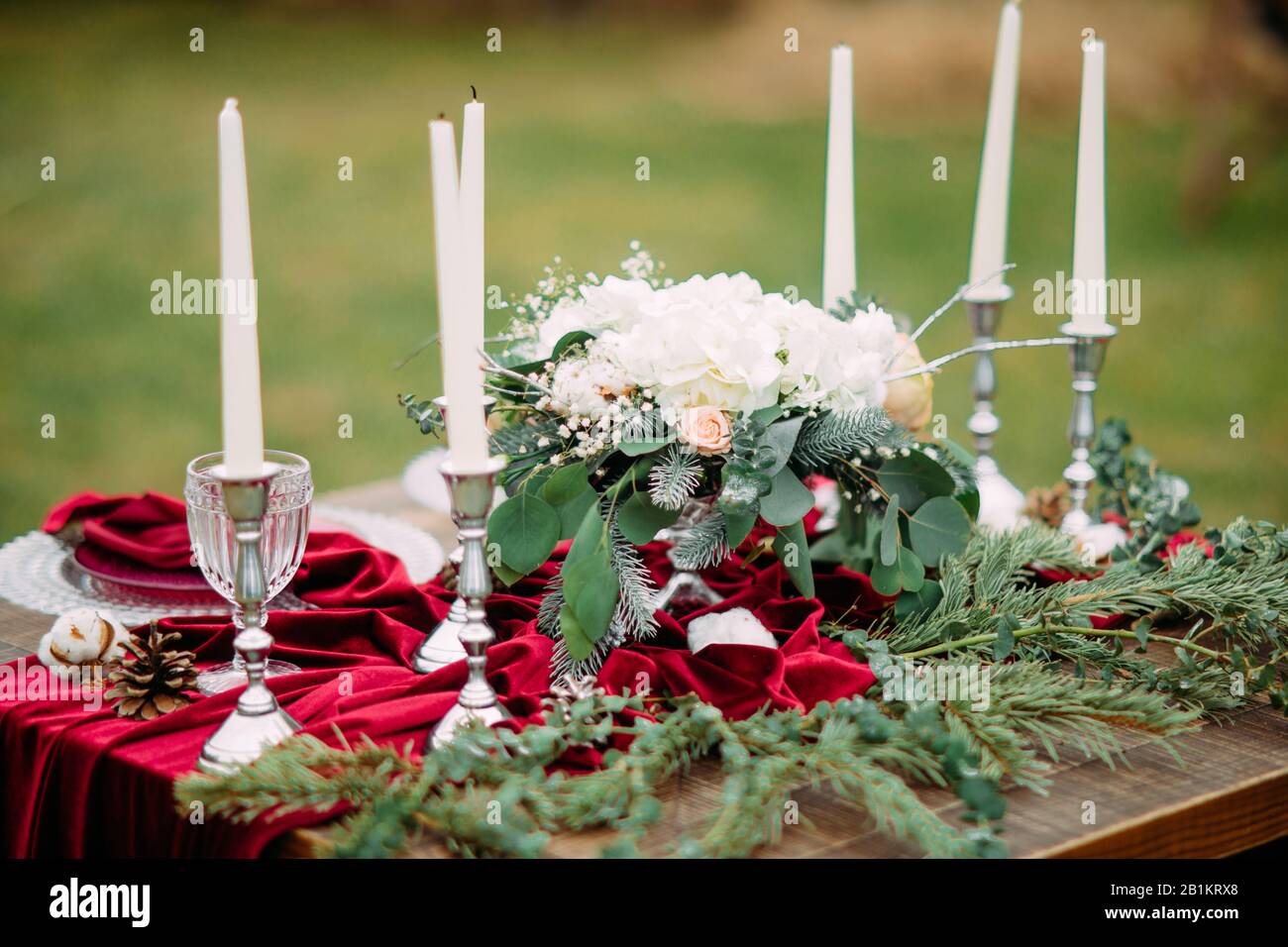 medio Intacto Rizado Mesa para banquetes de boda con velas en candelabros, platos, copas para  vino, arreglos florales y mantel rojo. Primer Plano Fotografía de stock -  Alamy