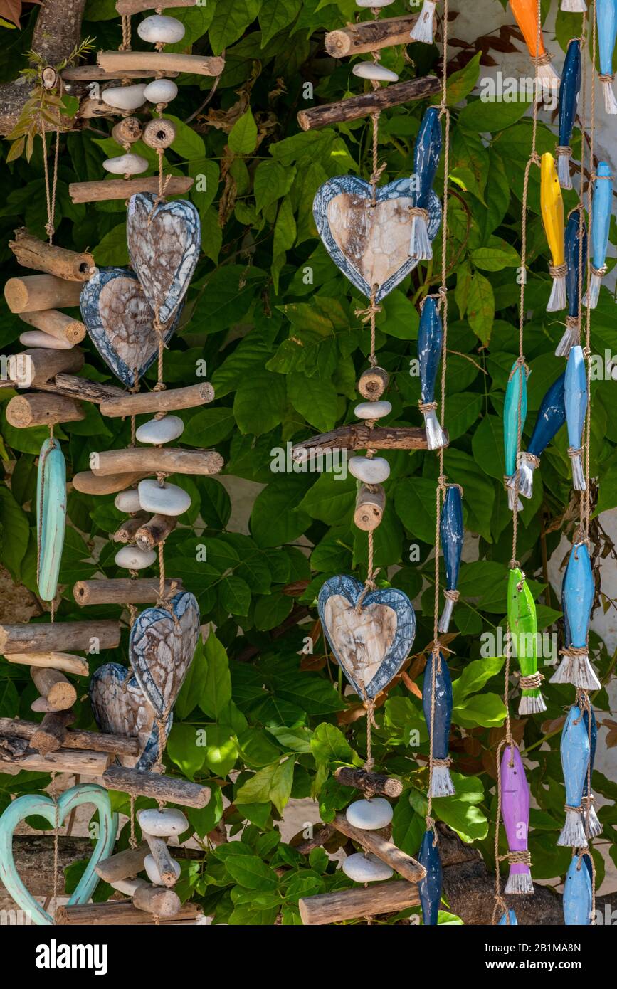 móviles colgantes decorativos hechos de madera y madera con corazones y peces de un techo en un regalo o tienda de ropa de casa en mal estado Fotografía