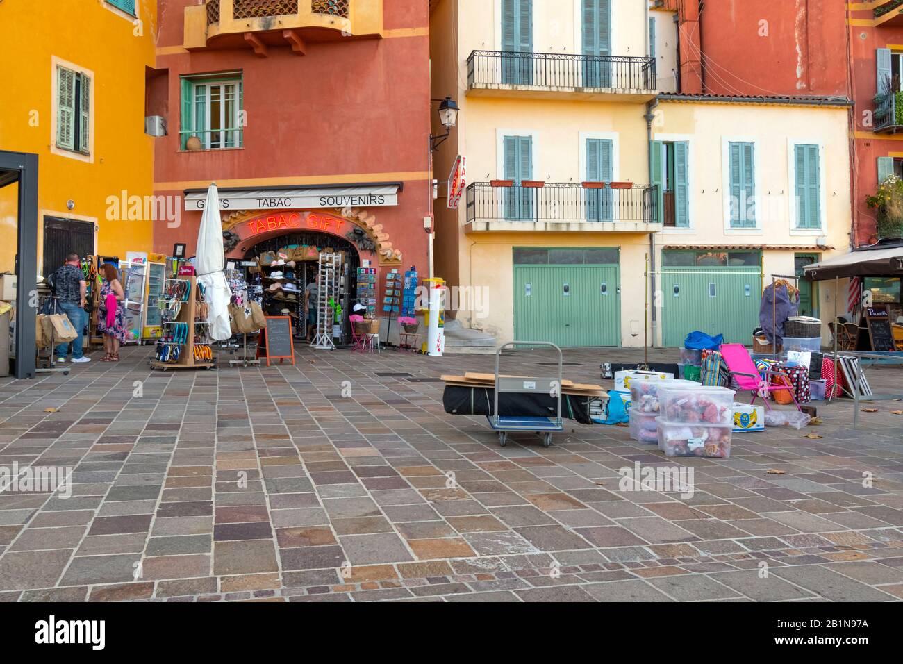 Los comerciantes se ponen y empacan sus mercancías después de un mercado al aire libre en la ciudad mediterránea de Villefranche Sur Mer, Francia Foto de stock