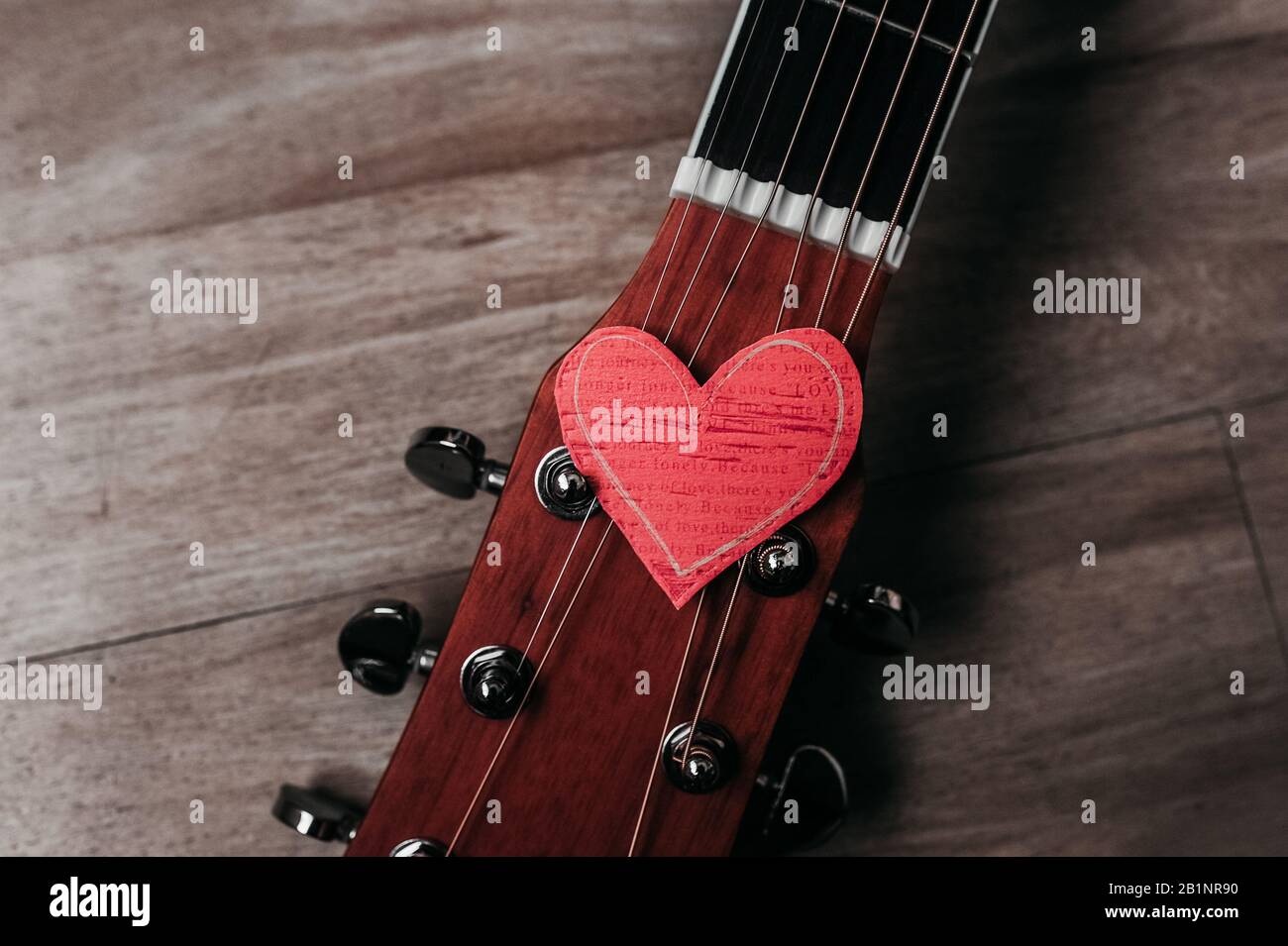 6 cuerdas de metal en una guitarra y un corazón de papel respetuoso con el  medio ambiente en ella, una imagen para un ser querido en vacaciones o  sobre un amor por