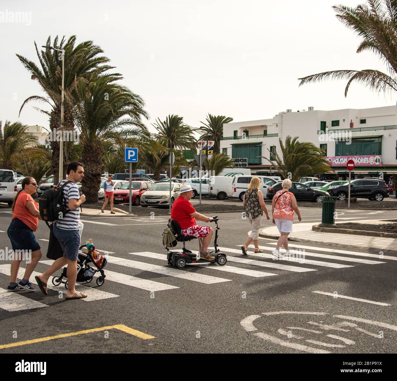 Personas con discapacidad que viajan en scooter con un cruce de cebra para  cruzar una carretera en Lanzarote Islas Canarias España Fotografía de stock  - Alamy