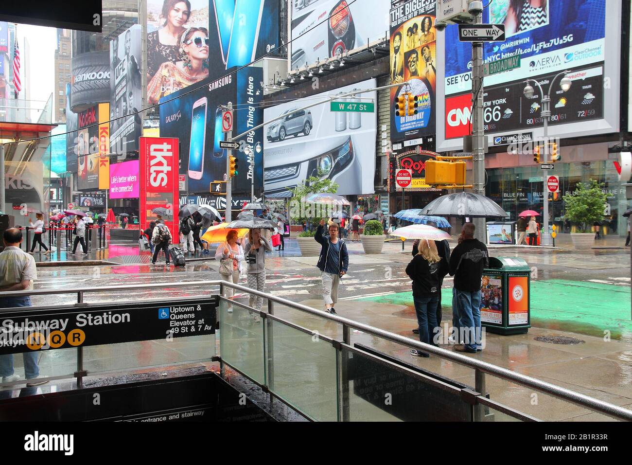Nueva York, Estados Unidos - Junio 10, 2013: la gente camina en la lluvia de Times Square, en Nueva York Times Square es uno de los lugares más reconocidos en el mundo. Más de 300.000 Foto de stock