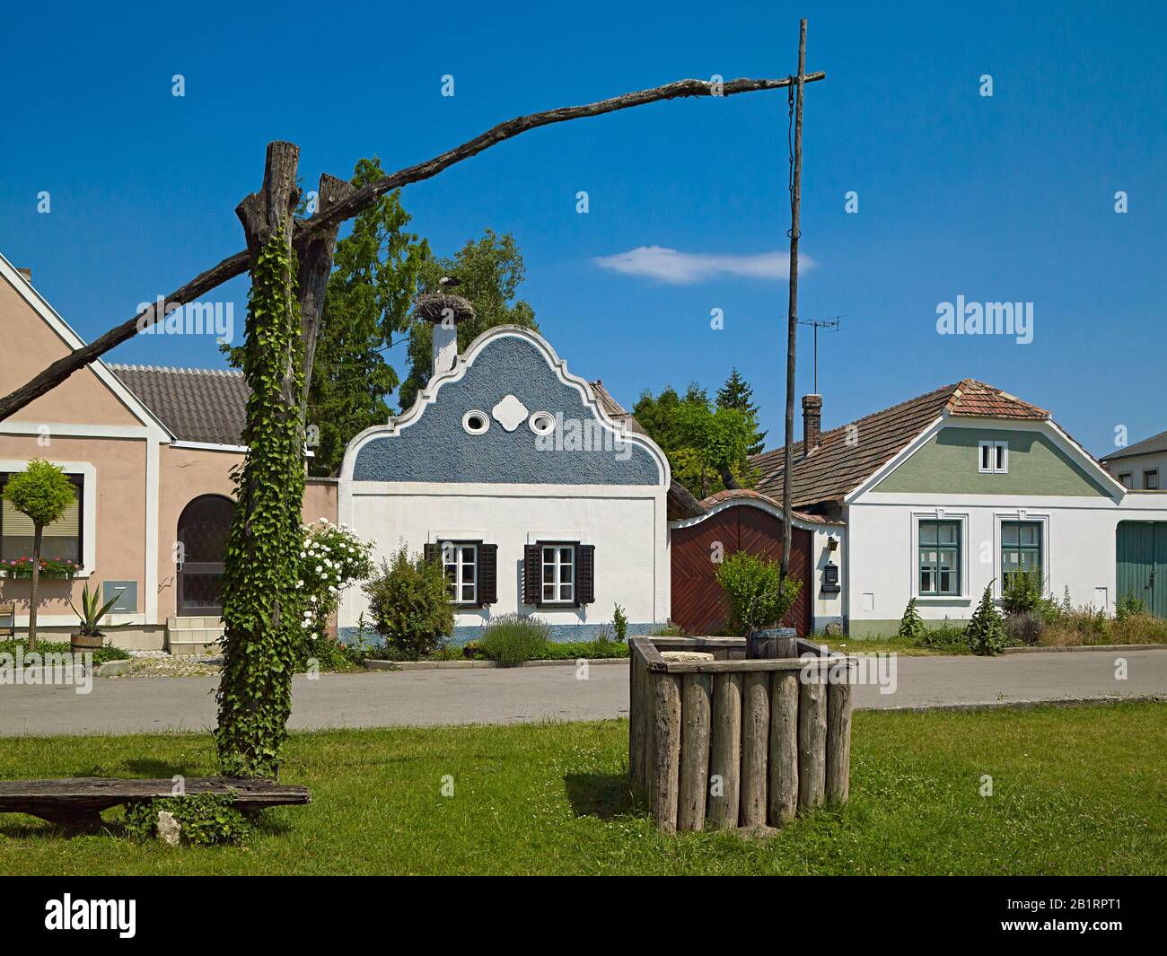 Hufnagelhaus, granja de Burgenland con frontón barroco y fuente de dibujo en Apetlon, Burgenland, Austria, Foto de stock