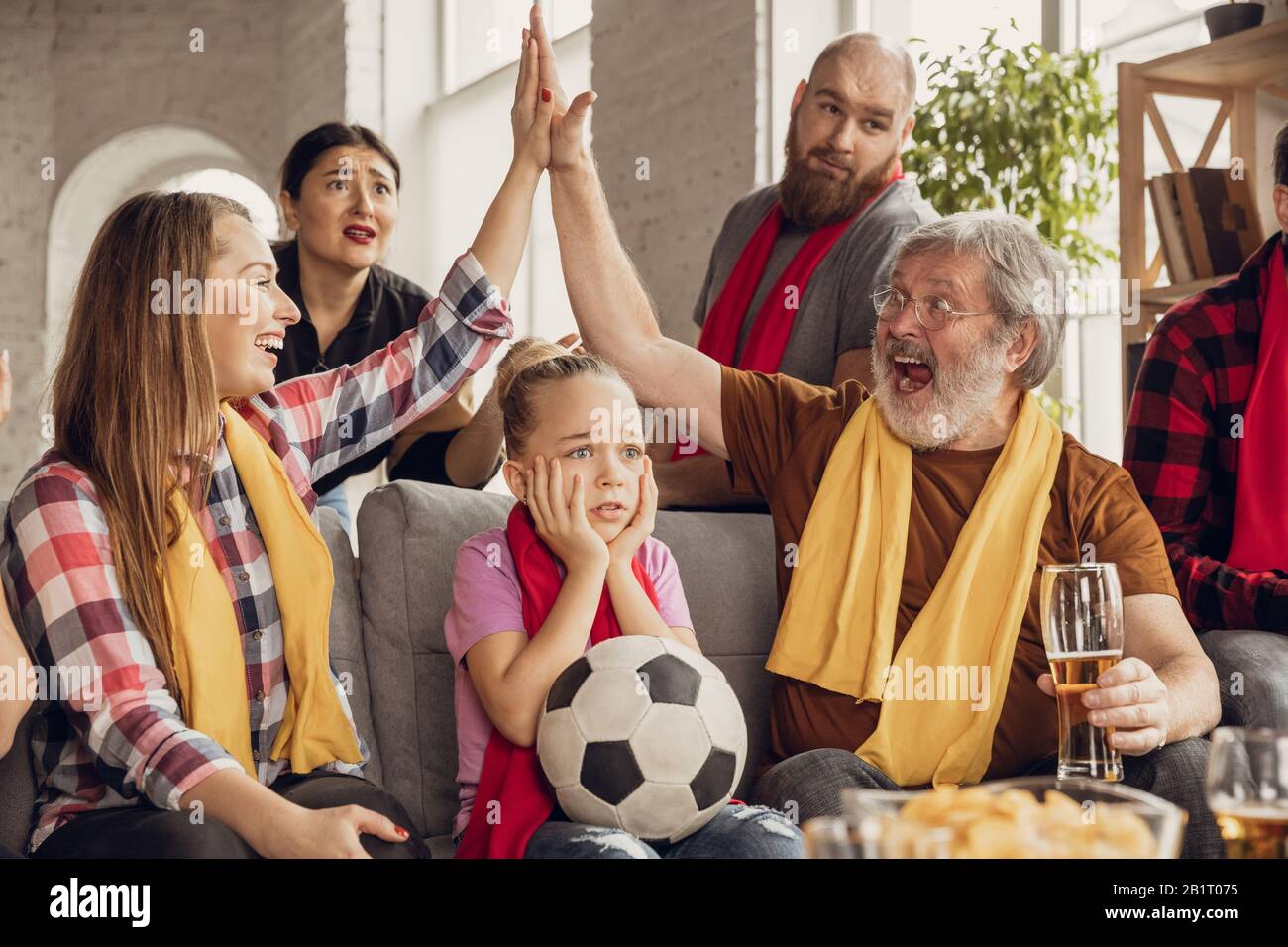 Emocionado, feliz familia grande viendo fútbol, partido de fútbol en el  sofá en casa. Fans animan emotivo a tu equipo nacional favorito. Divertirse  de los abuelos a los niños. Deporte, TV, campeonato