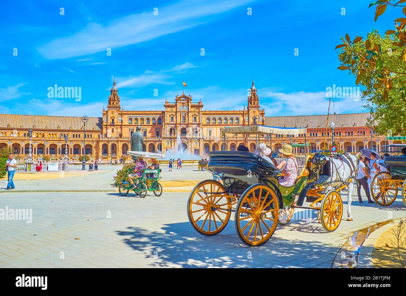 Sevilla, ESPAÑA - 1 DE OCTUBRE de 2019: La línea de carruajes turísticos tirados por caballos a la sombra de los árboles del parque de María Luisa con vistas a la Plaza de España, Foto de stock