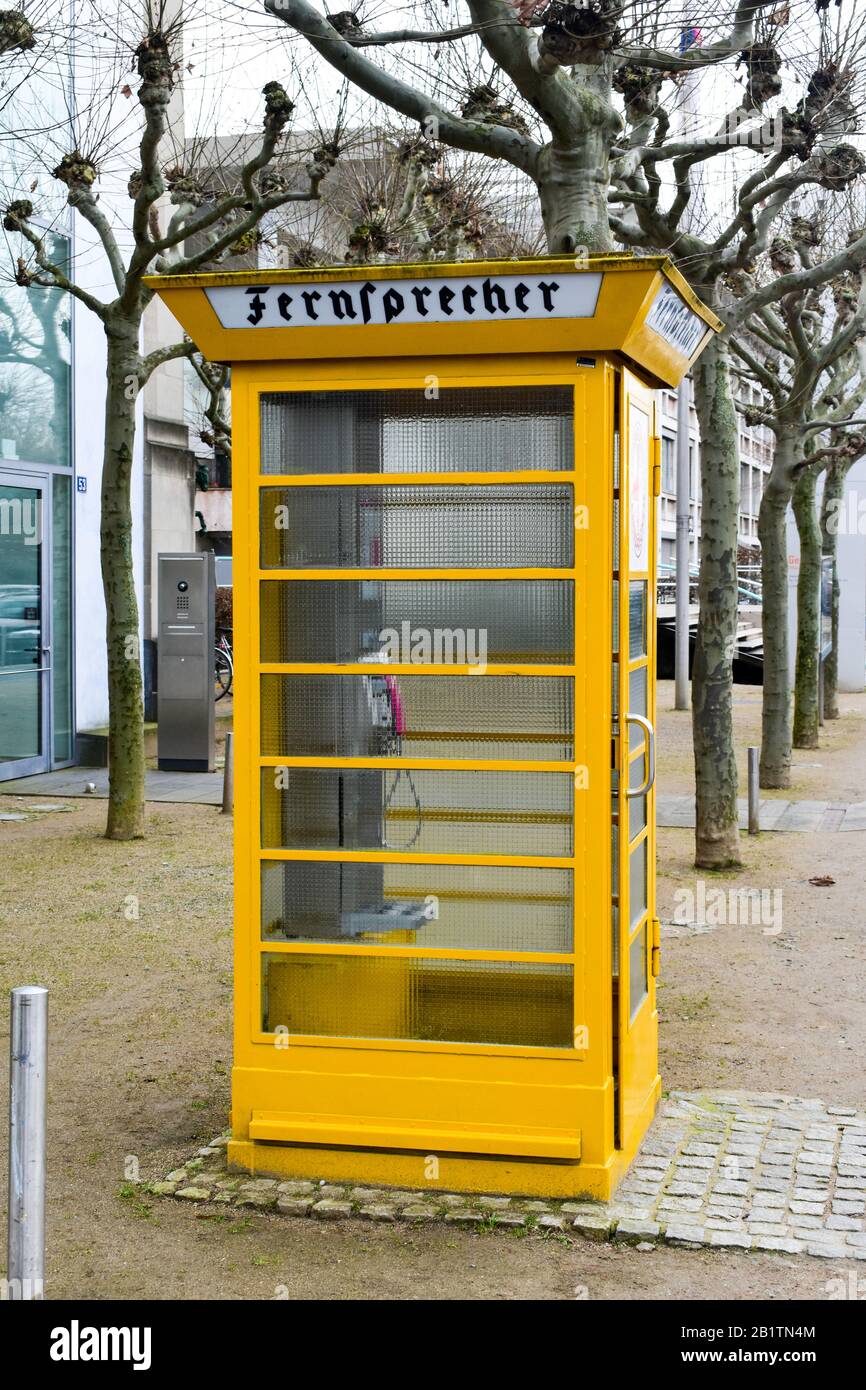 Caja de teléfono alemana de color amarillo vintage. Foto de stock