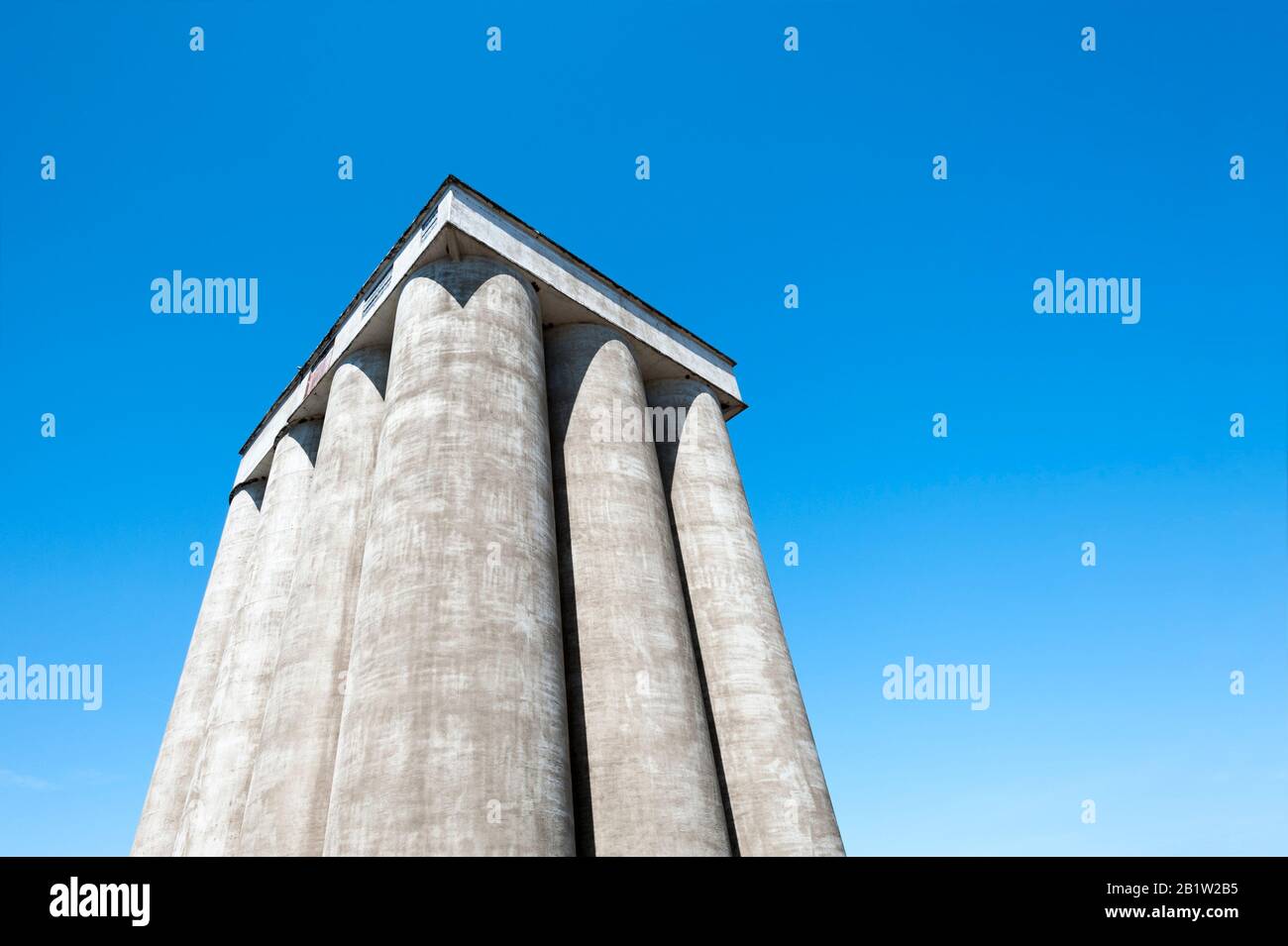 CopySpace disponible en esta imagen de mirar hacia arriba en la parte superior de los tubos de almacenamiento hechos de concreto de un granero y azul cielo claro. Foto de stock