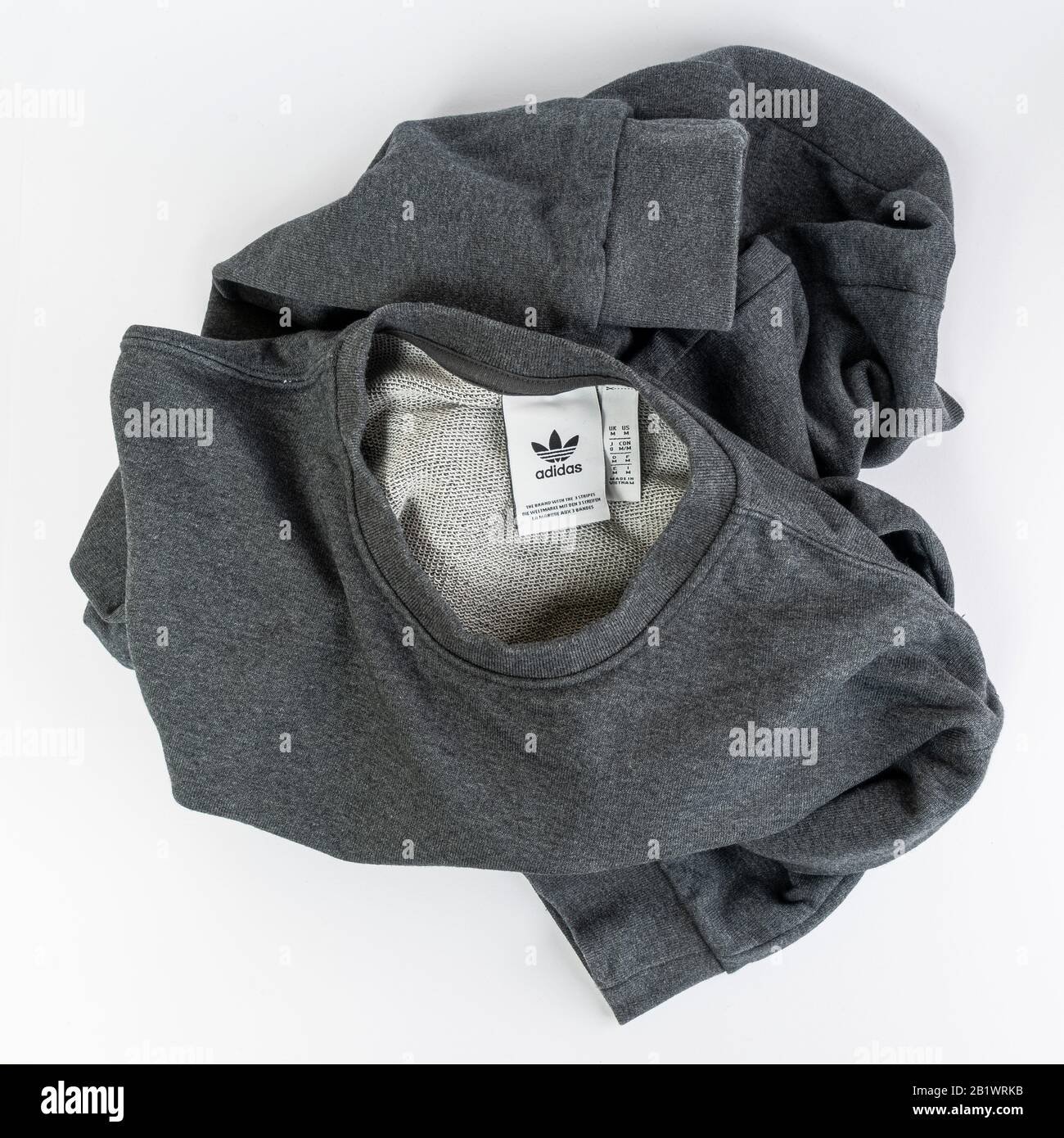 La Marca Adidas etiqueta la en una camisa de algodón gris Foto de stock