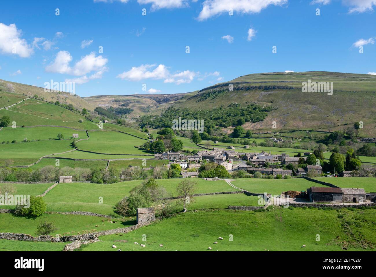 Vista de verano del pueblo de Yorkshire Dales de Muker en Swaledale rodeado por un paisaje clásico de Yorkshire de prados y páramos Foto de stock