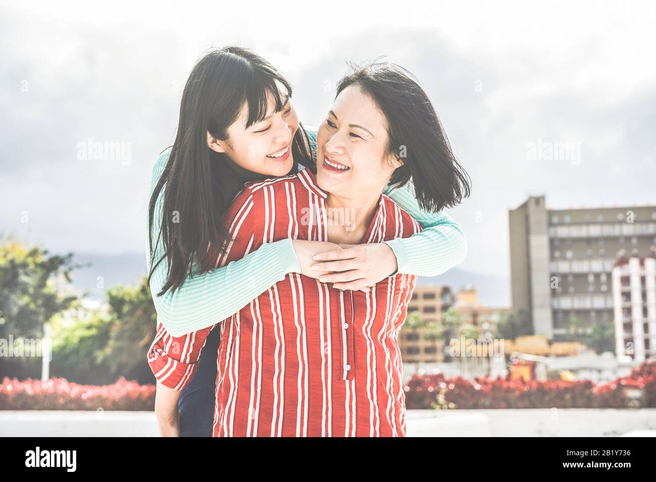 Madre e hija asiáticas divertirse al aire libre - Feliz familia gente disfrutando del tiempo togehter alrededor de la ciudad en Asia - Amor, estilo de vida de paternidad, mamá tierna Foto de stock