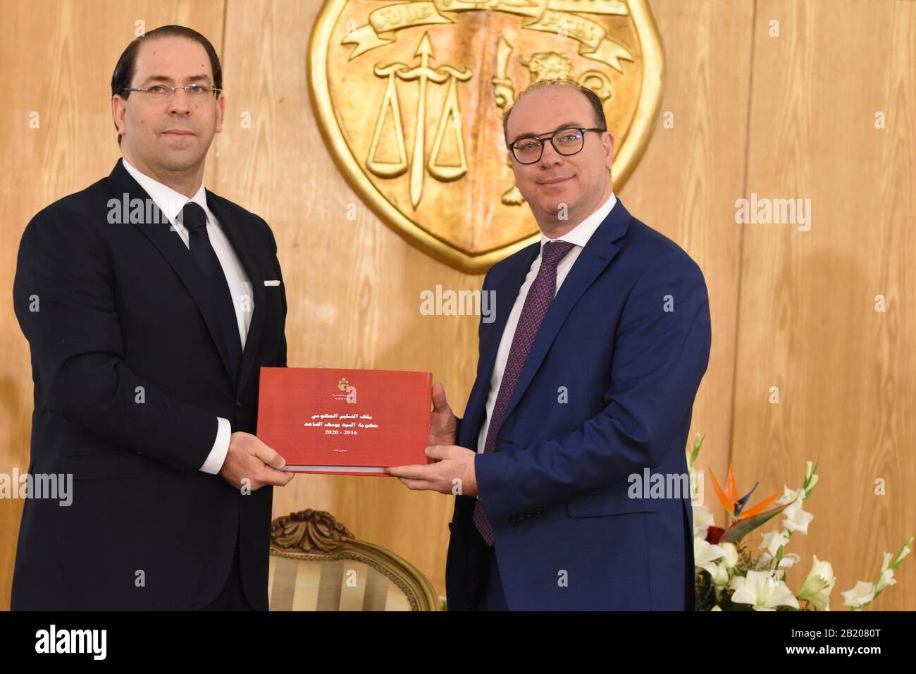 Túnez, Túnez. 28 de febrero de 2020. El primer Ministro saliente Youssef Chahed (L) y su sucesor Elyes Fakhfakh asisten a una ceremonia de transferencia de poder en Túnez, Túnez, el 28 de febrero de 2020. El viernes Elyes Fakhfakh asumió formalmente sus funciones como jefe del nuevo gobierno tunecino, dijo la presidencia tunecina. Durante la ceremonia de transferencia de poder, el primer Ministro saliente Youssef Chahed presentó a su sucesor Fakhfakh un informe detallado sobre los resultados de su gobierno durante el período 2016-2020. Crédito: Adele Ezzine/Xinhua/Alamy Live News Foto de stock