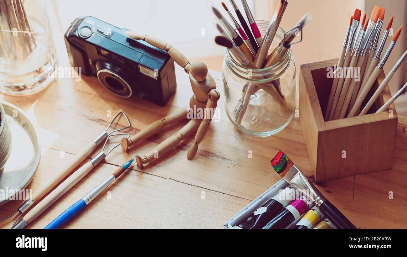 Foto de la mesa de trabajo del artista con accesorios. Vista superior de  artículos básicos de escritorio de diseño gráfico con fondo de textura de  madera. Conjunto de accesorios de artista CO