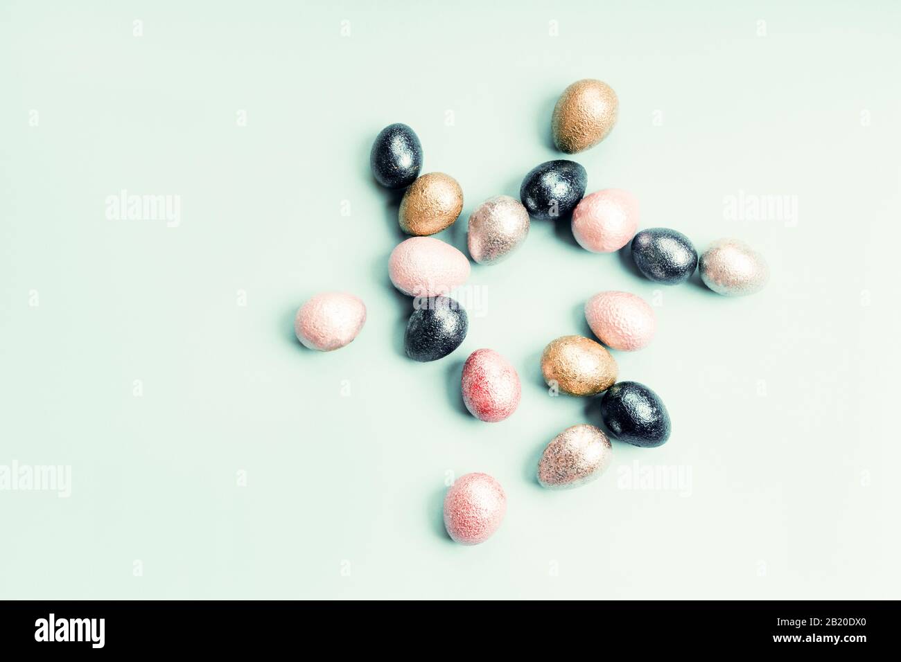 Pollo de perlas pintadas de colores y huevos de codorniz de color rosa, plateado, dorado y azul Foto de stock