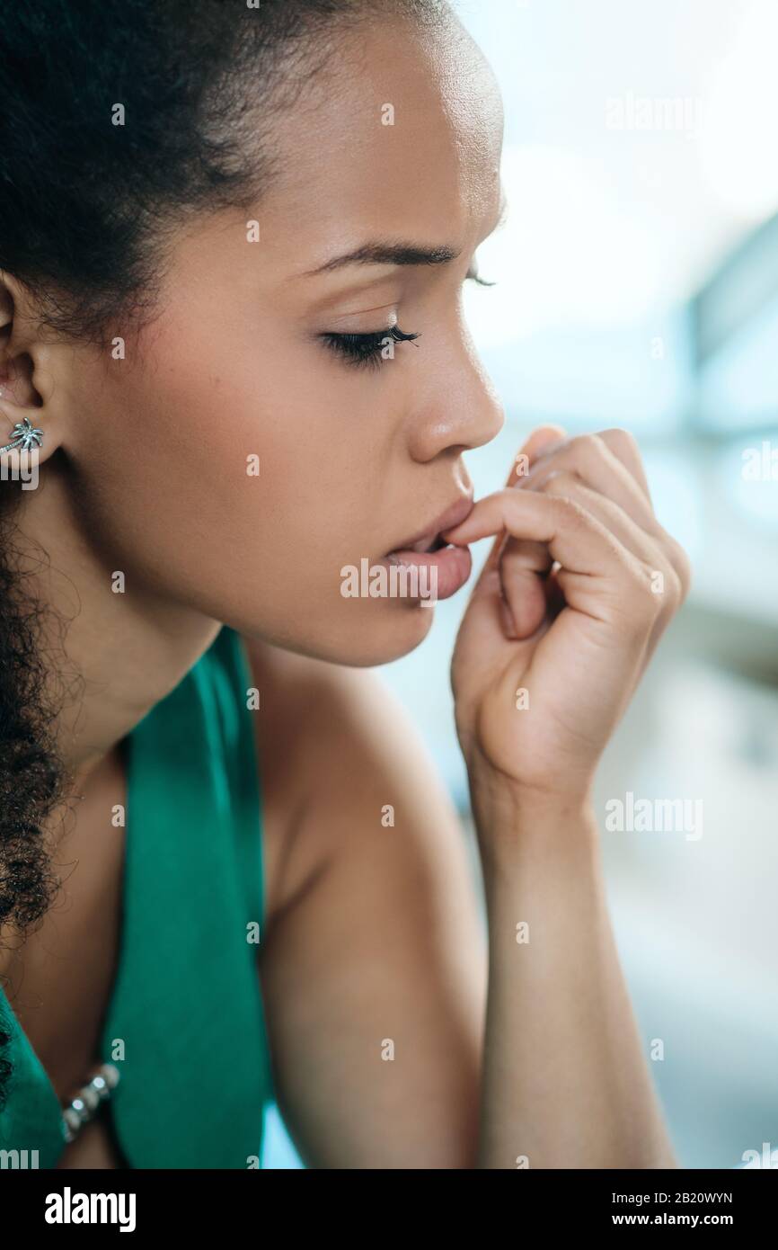 Joven Negro Mujer Sintiéndose Ansiosa Y Mordiendo Nails Foto de stock