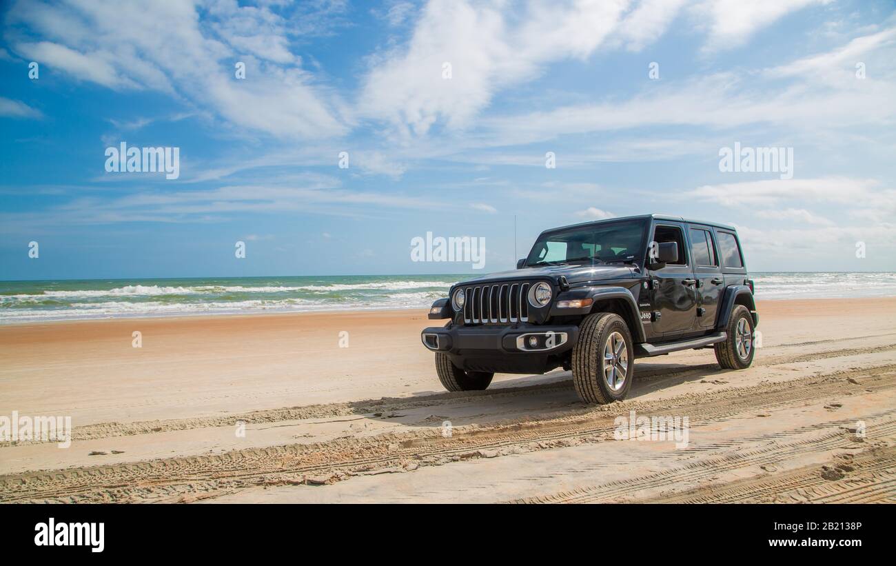 Jeep Wrangler conduce sobre la playa, Daytona Beach, Florida, Estados Unidos Foto de stock