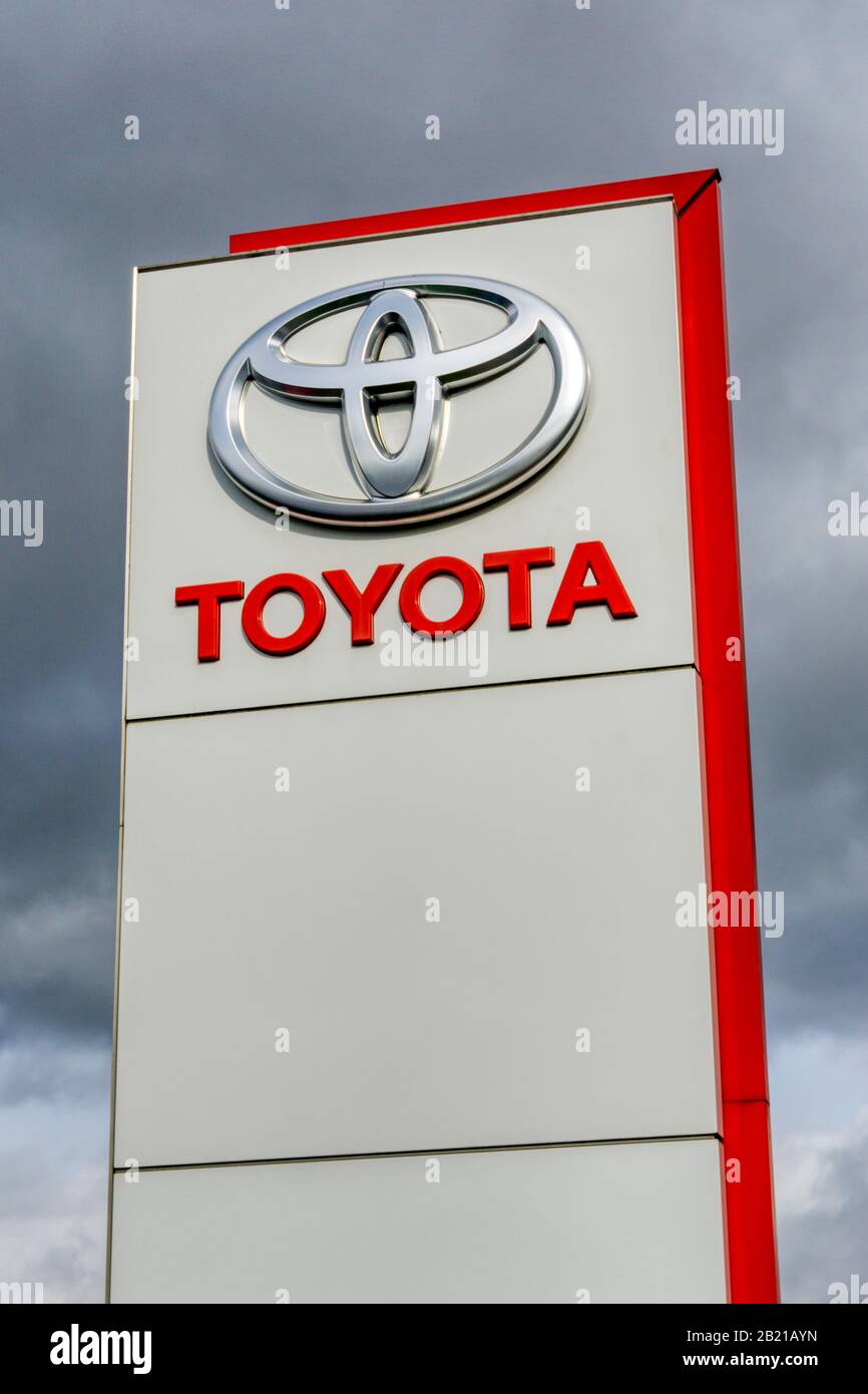 Logotipo grande de Toyota en un cartel fuera de una sala de exposición de coches Toyota. Foto de stock