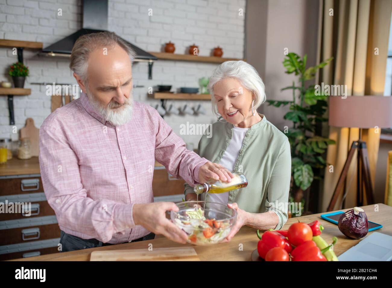 Las personas mayores cocinan juntos una ensalada sabrosa y saludable Foto de stock