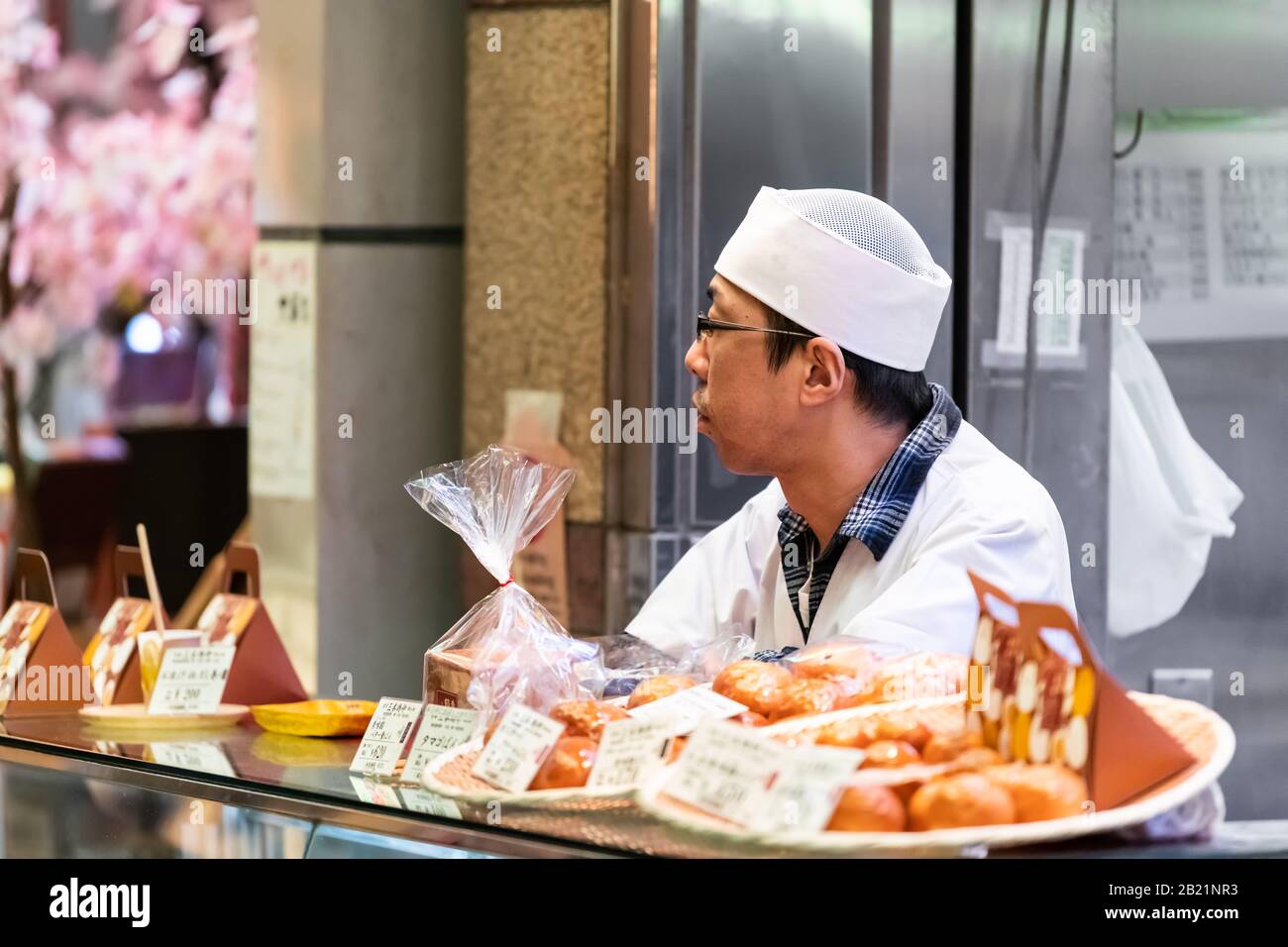 Kyoto, Japón - 17 de abril de 2019: Hombre de la gente chef que sirve en el mercado Nishiki tiendas de alimentos vendedor de la venta de pastel de arroz mochi dulces Foto de stock