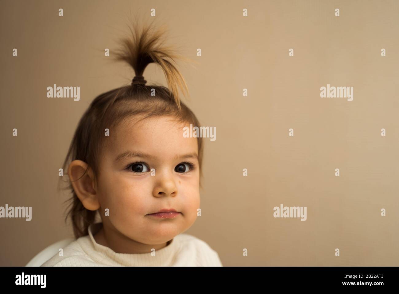 Niña pequeña con fuente de peinado y sonriendo con sus dientes Fotografía  de stock - Alamy
