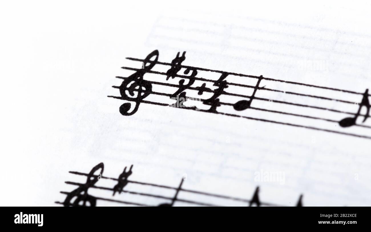 Tecla, símbolo de doble firma de tiempo y violin clef. Macro de notación musical, primer plano. Ejemplo de detalle de música con una sola hoja de línea, reproduciendo un instrumento Foto de stock