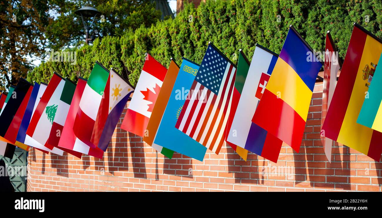 Fila de muchas banderas diferentes colgando de una pared de ladrillo  durante el día. Representación de países evento multicultural, mezcla de  símbolos patrióticos culturales Fotografía de stock - Alamy