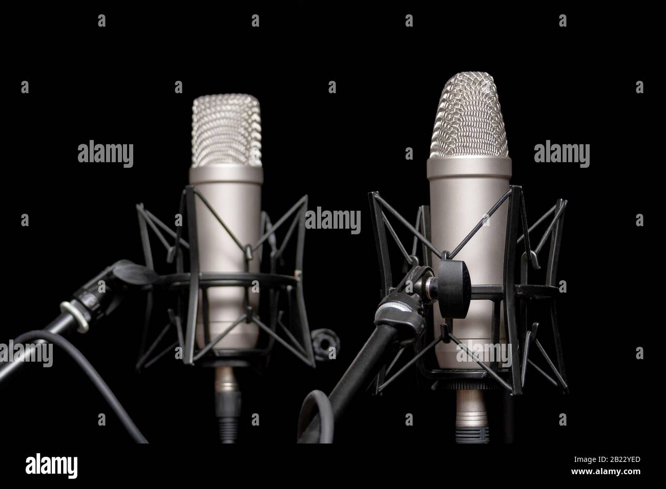 Dos micrófonos profesionales de estudio de plata sobre soportes sobre fondo  negro, podcasting, voz en off. Comentario de entrevistas o eventos  deportivos, grabación de voz Fotografía de stock - Alamy