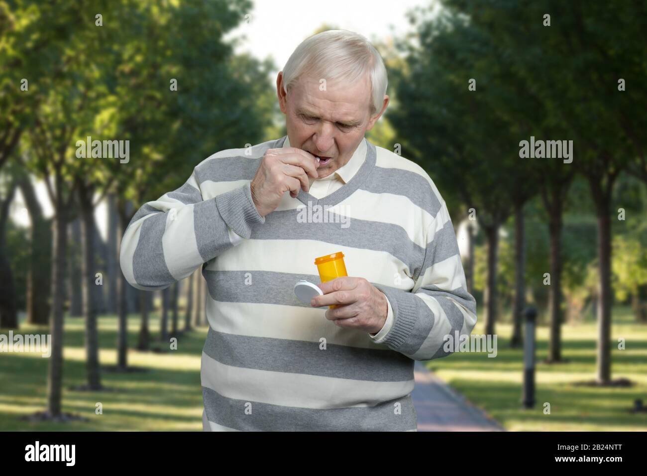 Retrato del anciano tomando pastillas. Foto de stock
