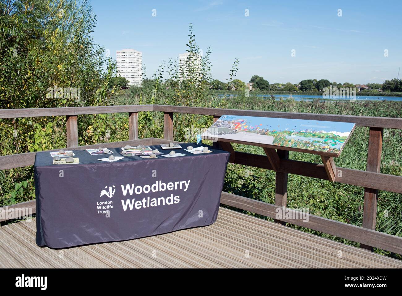 Tabla de información de London Wildlife Trust que contiene folletos con mapa de reserva a la derecha, con reservorio más allá de los humedales de Woodberry Foto de stock