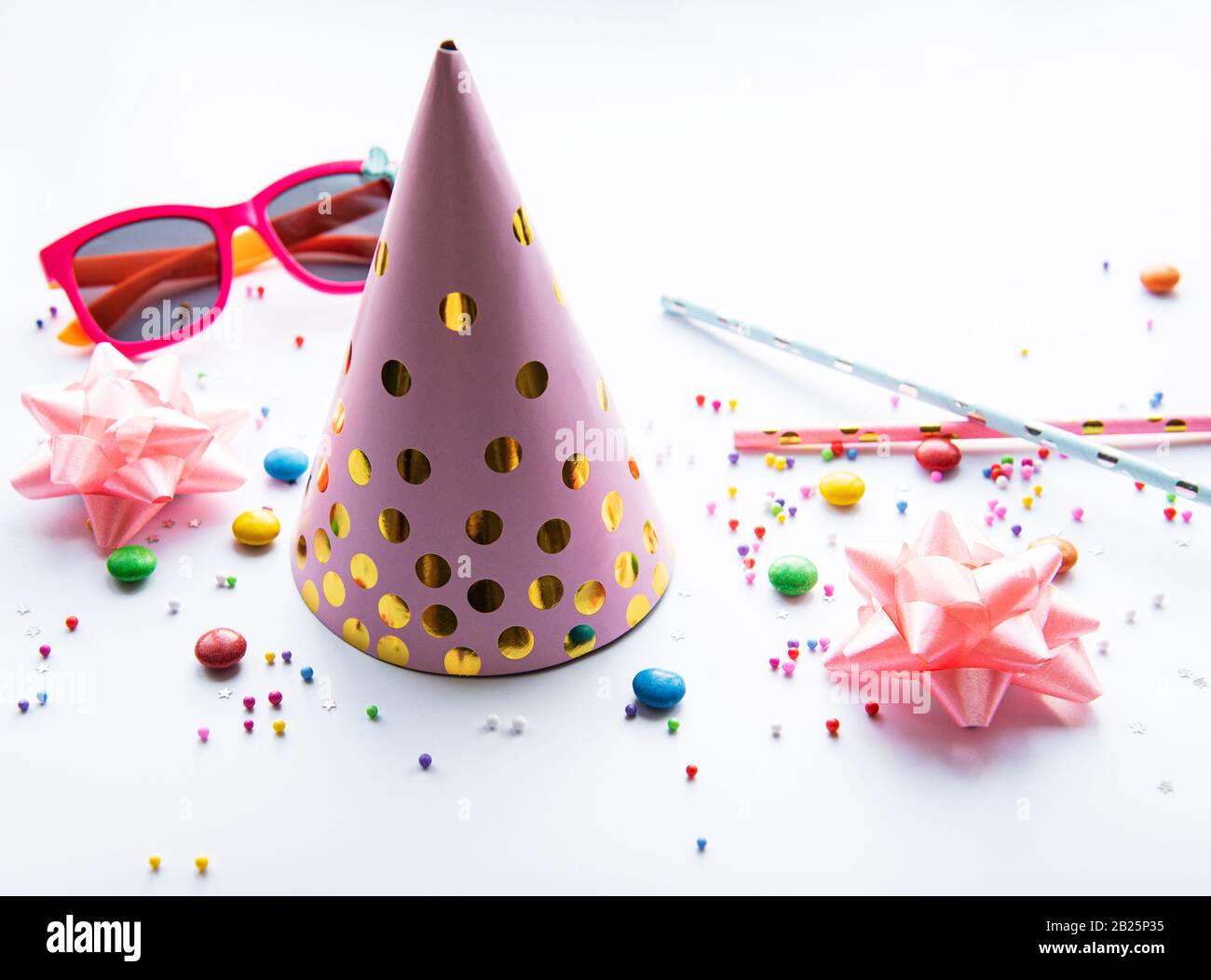 Cumpleaños fiesta tapas, decoraciones y confeti sobre un fondo blanco Foto de stock