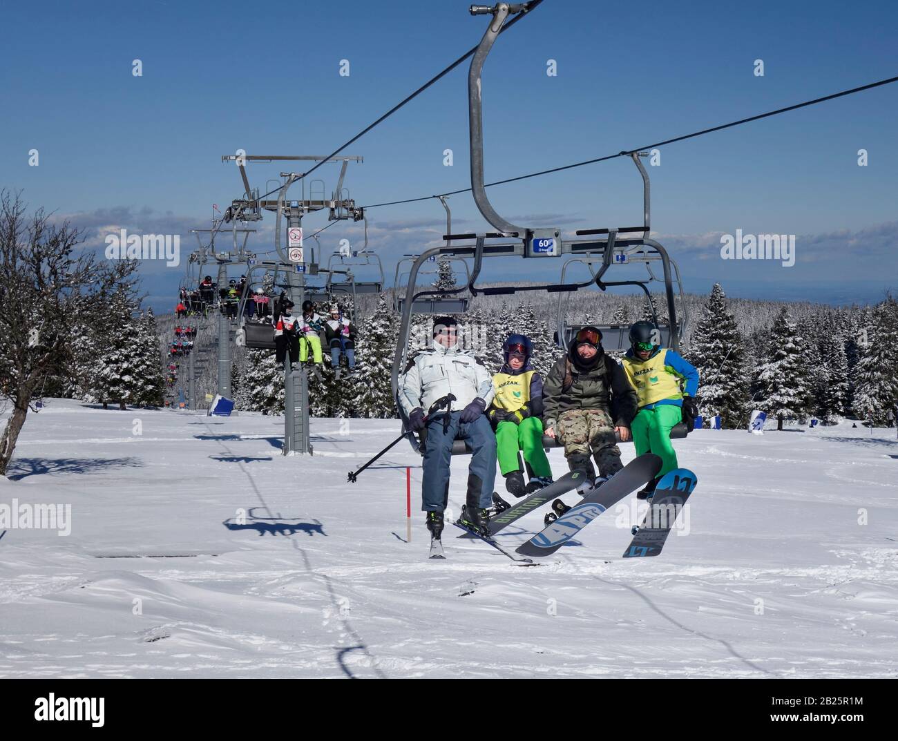 Los esquiadores se encuentran en el telesilla de esquí de la estación de esquí de Rogla, Eslovenia Foto de stock