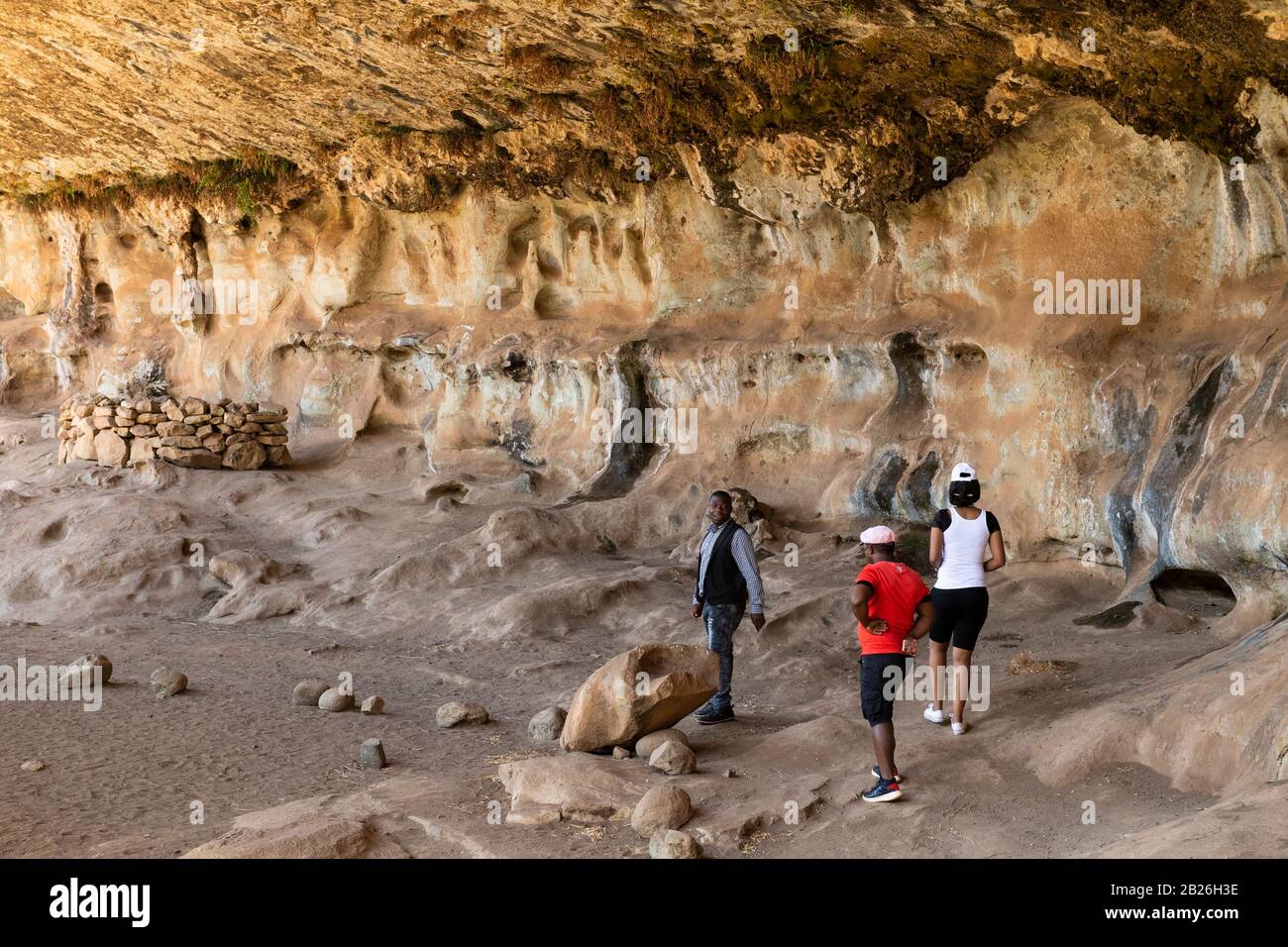 Gente que mira el arte rupestre en la cueva de Liphofung, Lesotho Foto de stock