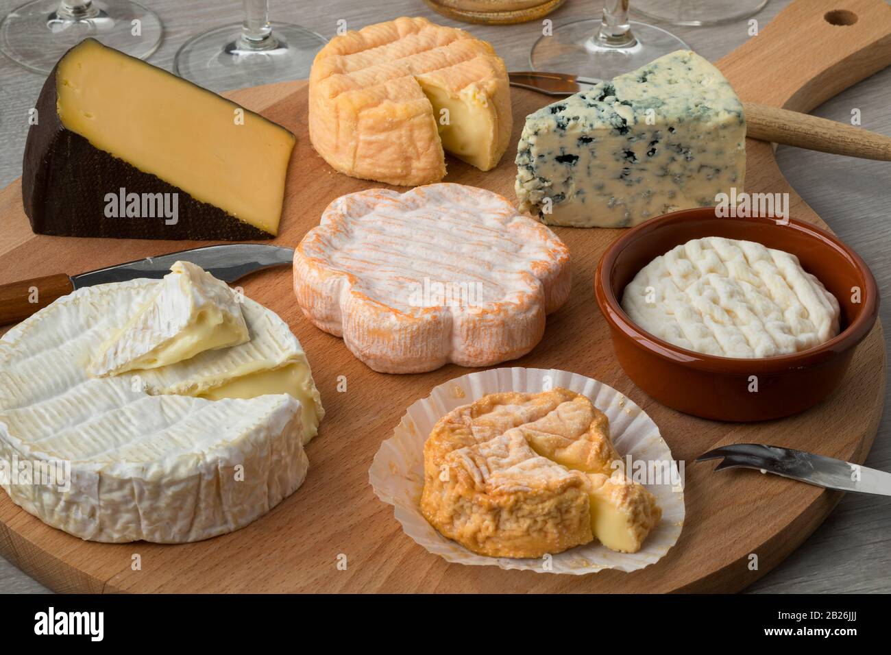 Tabla de quesos de madera con una gran variedad de quesos para primer plano Foto de stock