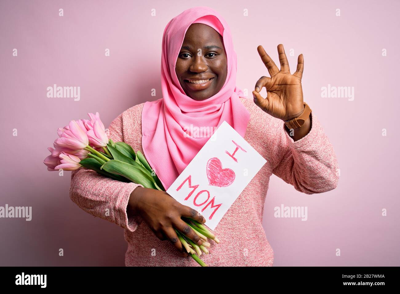 Más Tamaño De La Mujer Afroamericana Usando Hijab Sosteniendo Mensaje Y Tulipanes En El Día De 