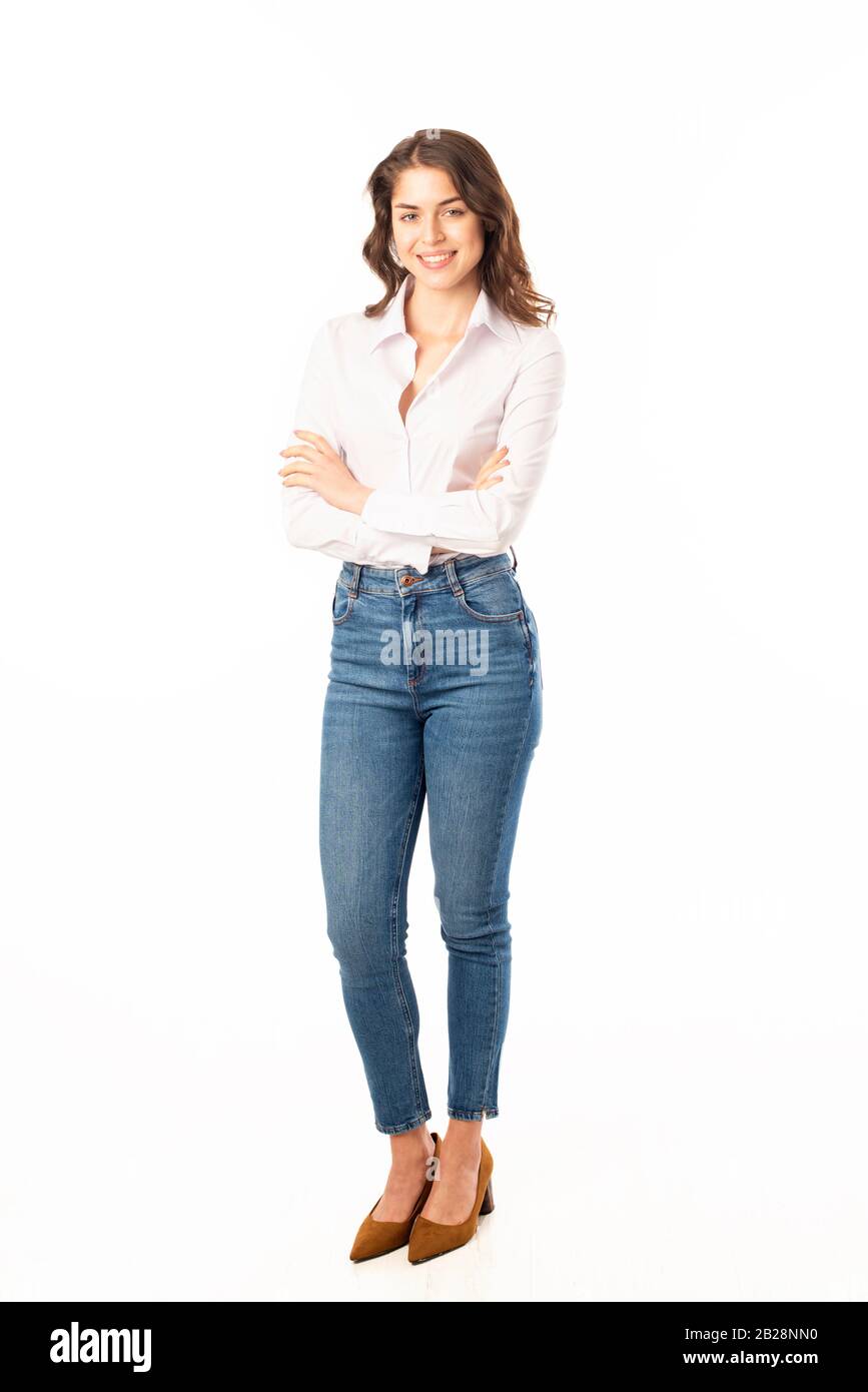 largo de mujer joven con camisa blanca y jeans azules mientras posan en un fondo blanco aislado Fotografía de stock - Alamy