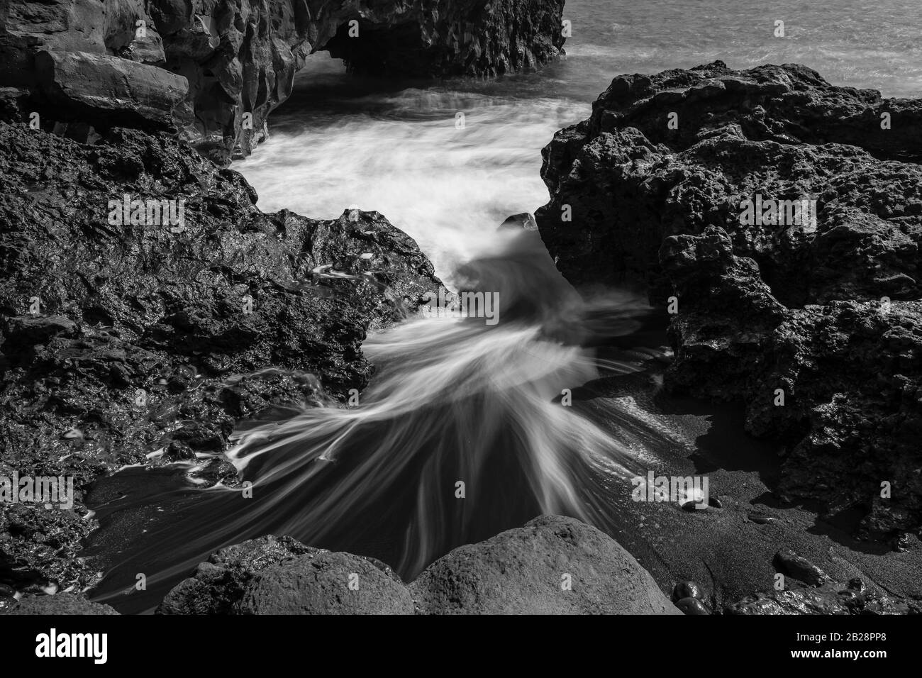 El agua se lava alrededor de piedras, arena de lava negra, playa, blanco y negro, la Palma, Islas Canarias, Islas Canarias, España Foto de stock