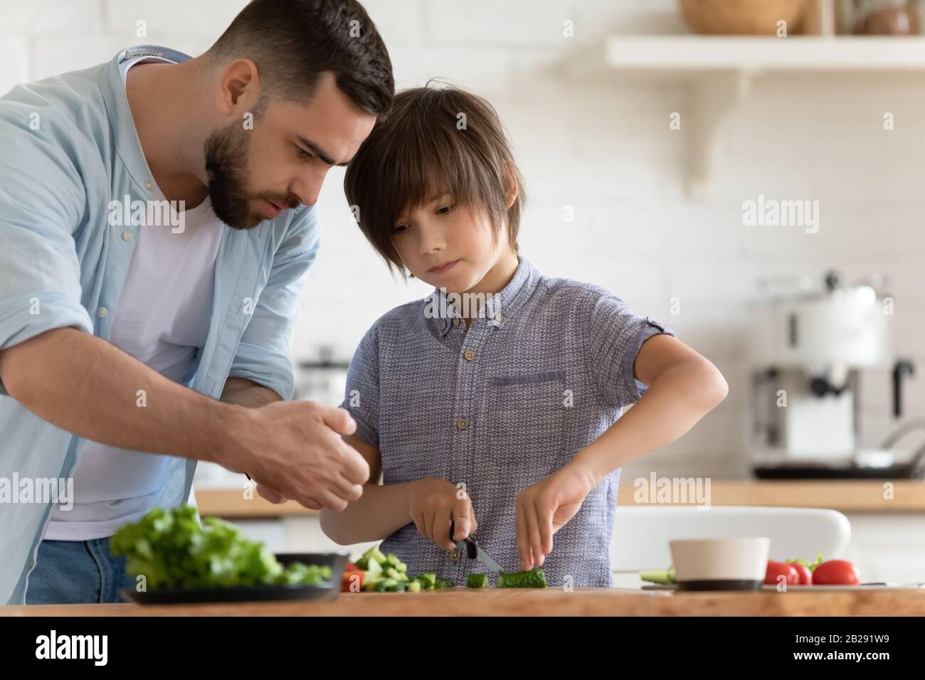 Padre amoroso y el hijo pequeño cocinando juntos en casa Fotografía de  stock - Alamy