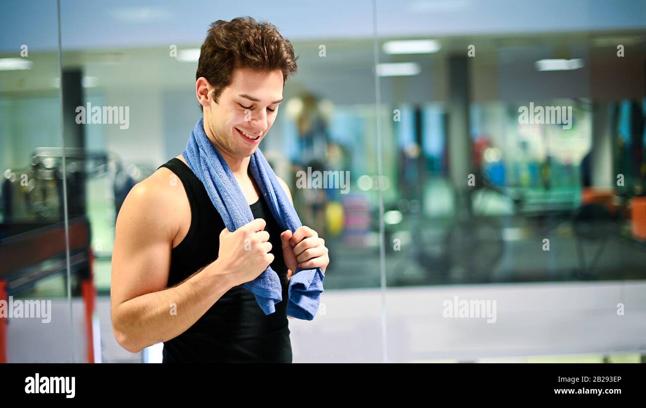 Colocar el hombre con una toalla alrededor de su cuello, en un gimnasio  Fotografía de stock - Alamy