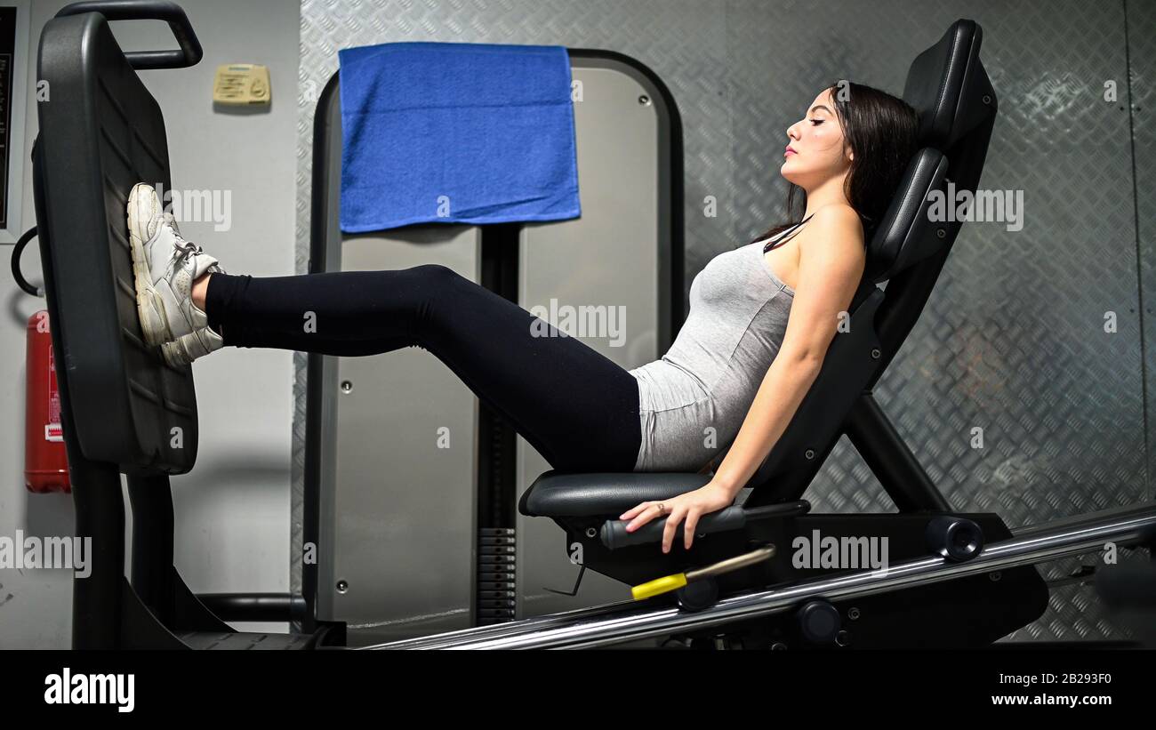Mujer usando una máquina de prensa para piernas en un gimnasio Fotografía  de stock - Alamy