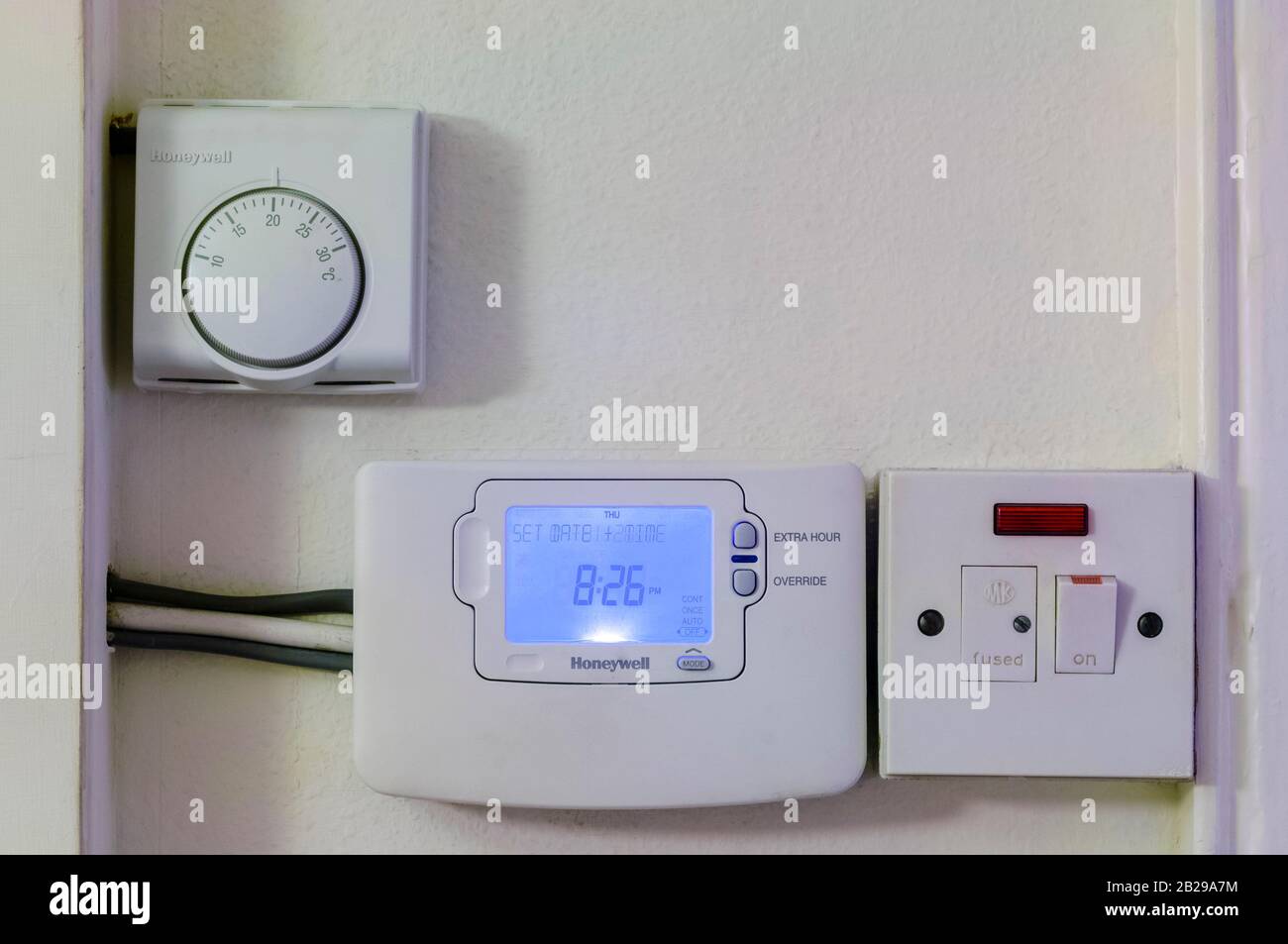 Instalado en una pared, un termostato Honeywell ajustado a veinte grados,  temporizador de calefacción central e interruptor de corte eléctrico  Fotografía de stock - Alamy