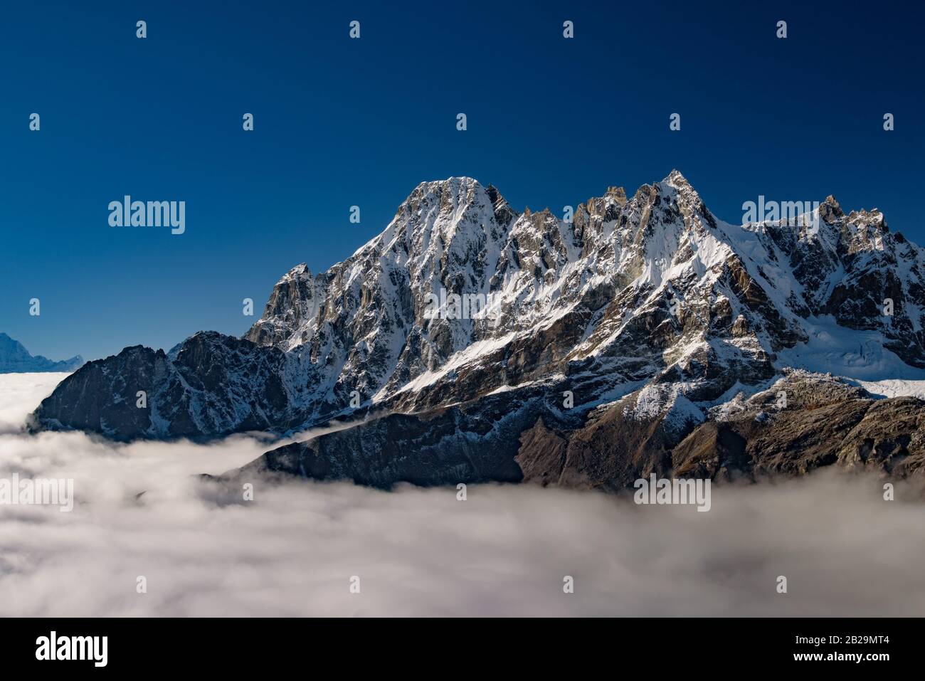 Montañas nevadas del Himalaya por encima de las nubes en Nepal Foto de stock