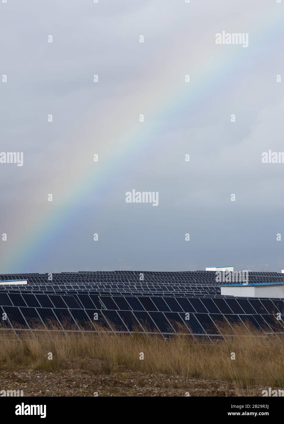 arco iris y paneles fotovoltaicos de una central solar Foto de stock