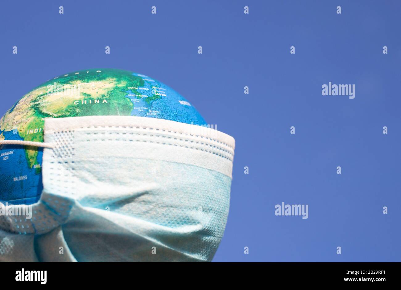 coronavirus alerta mundial - máscara quirúrgica en el globo Foto de stock