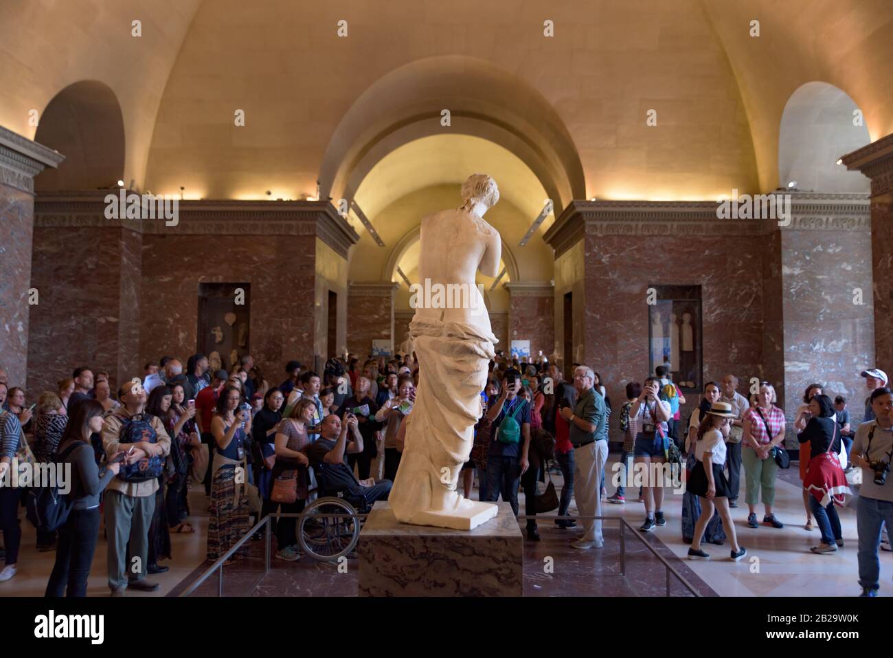 Gente alrededor de Venus de Milo (Afrodita de Milos), una de las esculturas griegas antiguas más famosas, en exhibición en el Museo del Louvre en París, Francia Foto de stock