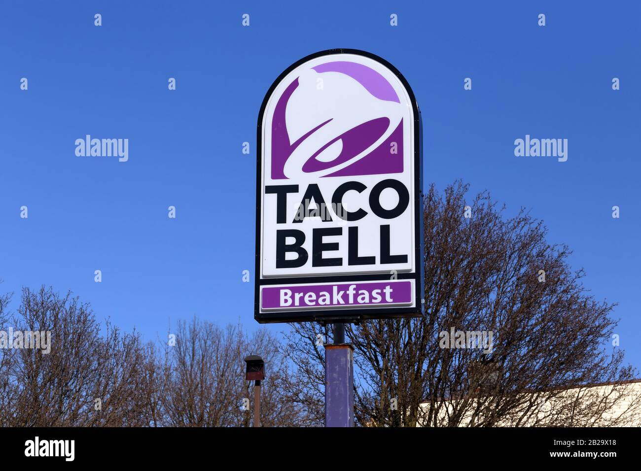 Un cartel de Taco Bell en un poste contra un cielo azul soleado. Foto de stock
