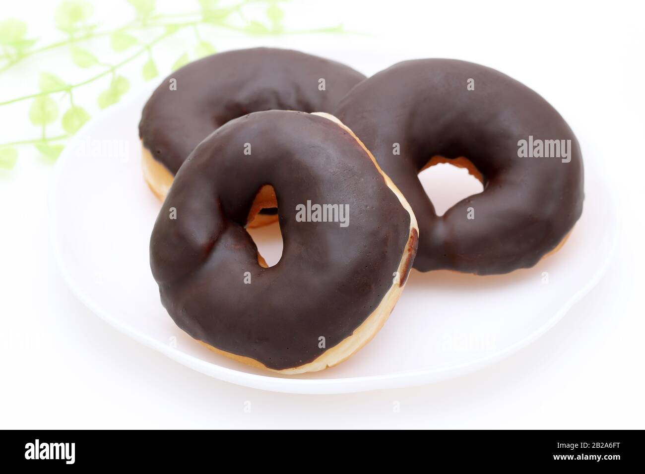 Donut con chocolate en un plato sobre fondo blanco. Primer plano Foto de stock