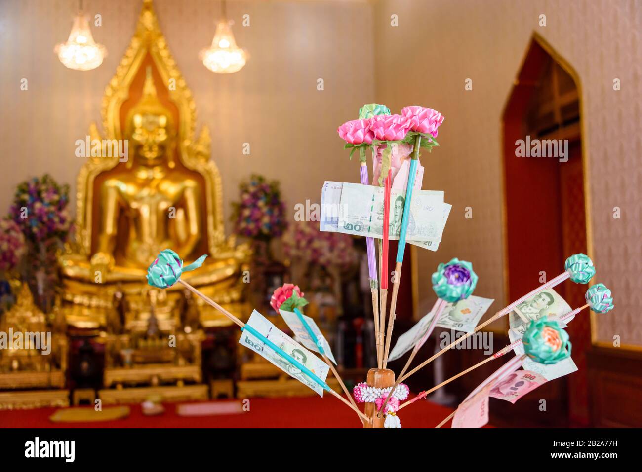 Regalos de billetes delante de una estatua de oro de Buda, Wat Songkhram, Bangkok, Tailandia Foto de stock