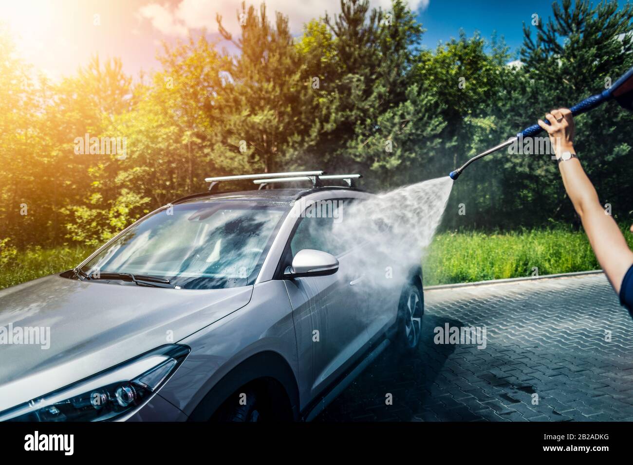 Lavado de autos manual con agua presurizada en lavado de coche fuera. Foto de stock
