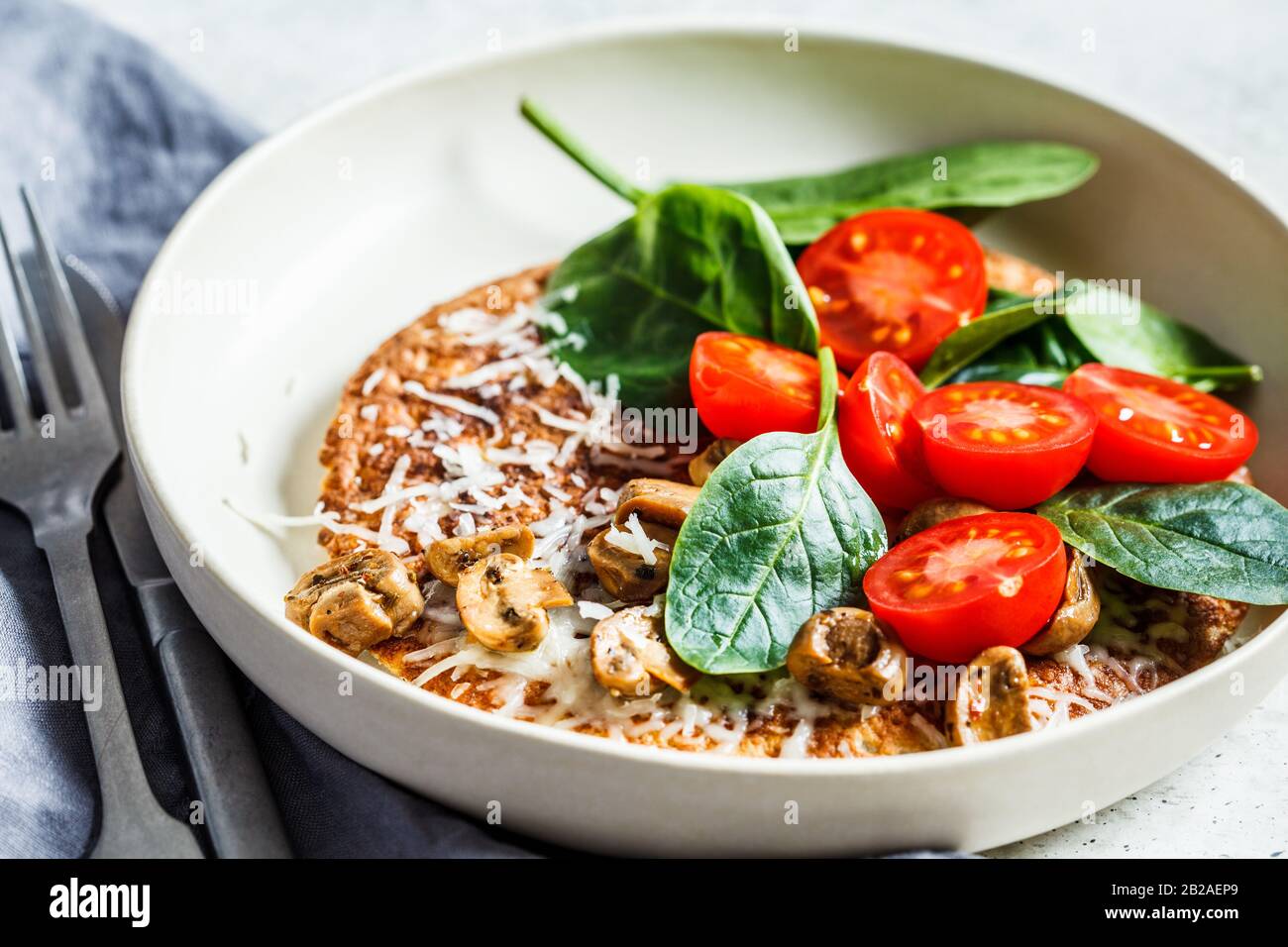 Tortilla de avena con queso, tomates y espinacas. Desayuno saludable