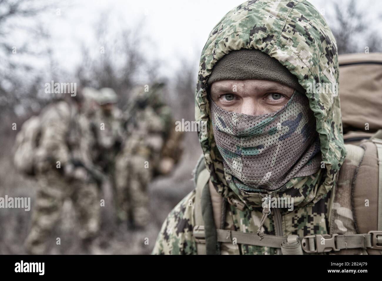 Retrato de hombro de soldado de infantería del ejército, miembro del grupo  táctico en uniforme de camuflaje, llevar mochila, usar capucha de  camuflaje, ocultar cara Fotografía de stock - Alamy
